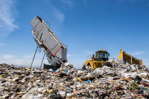 Modern  hydraulic disposer empties a complete trailer, while bulldozer manages landfill.